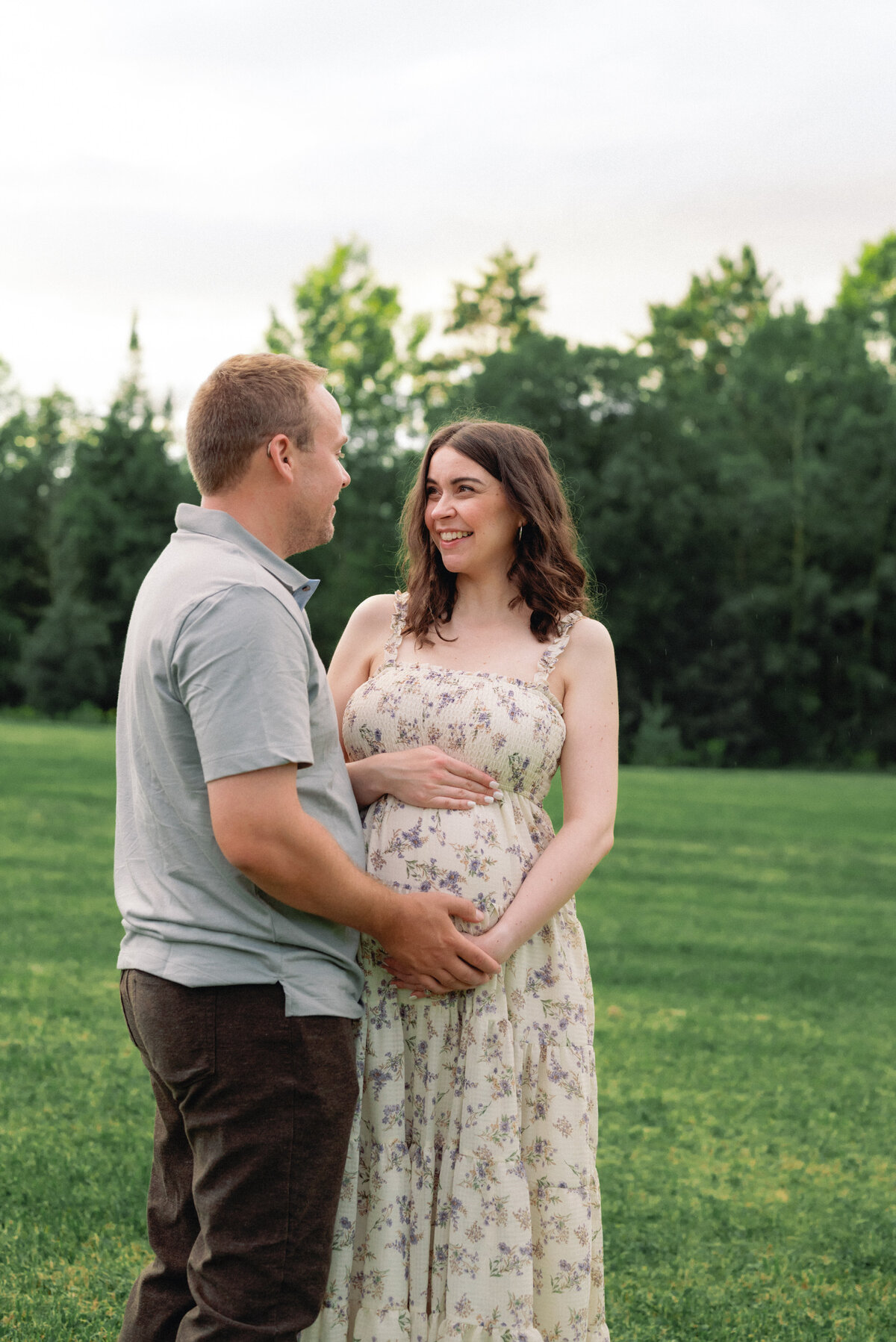 Expecting mother laughing while holding baby bump