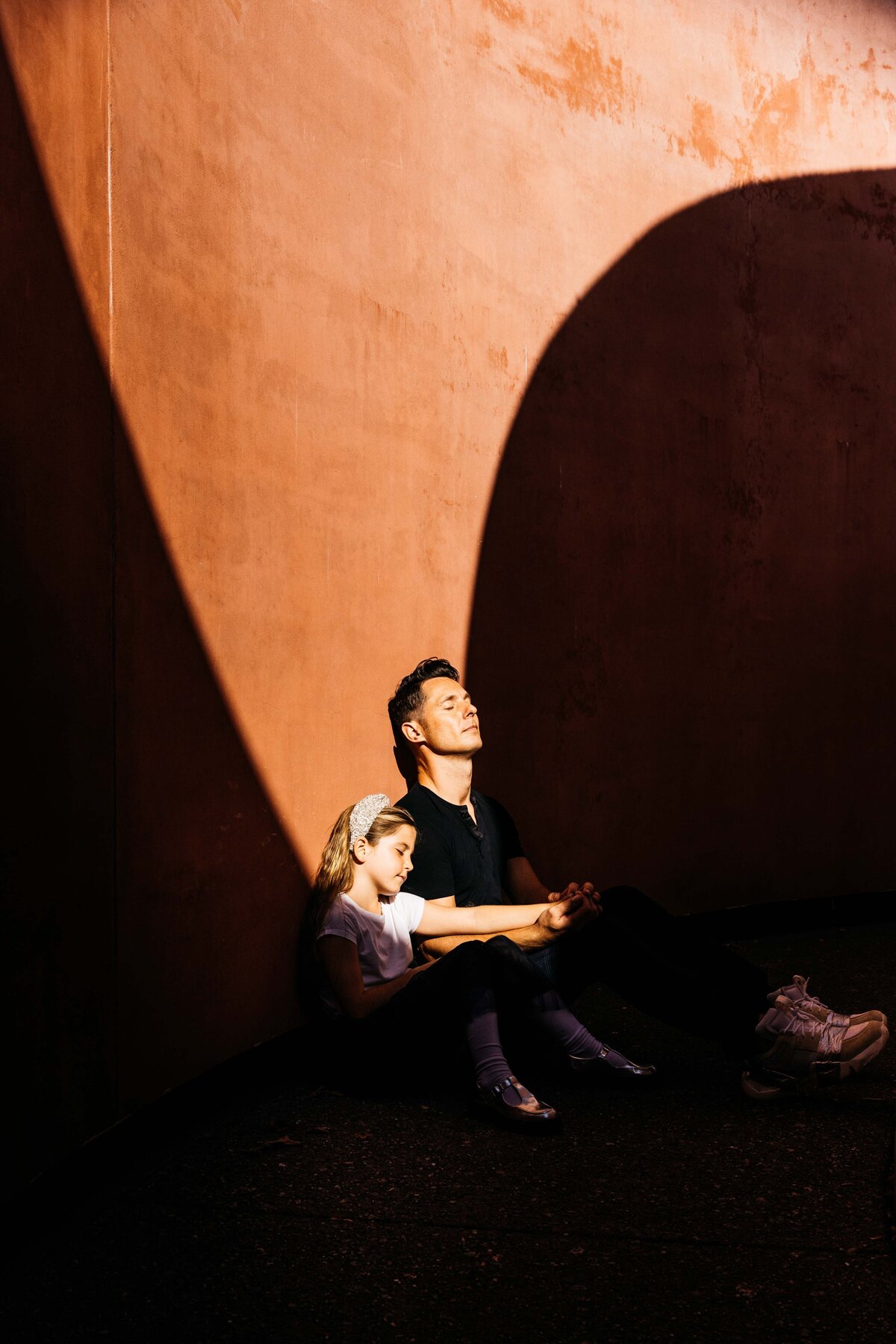 Father and daughter are closing their eyes and basking in the sun.