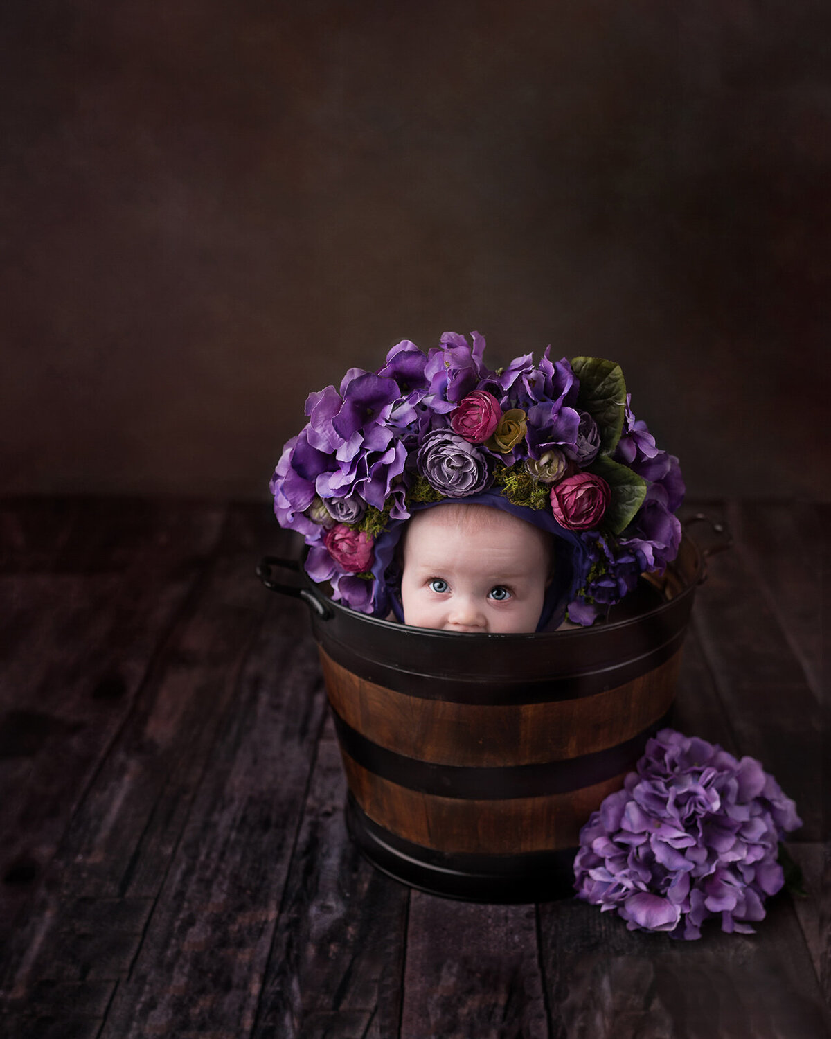 Cute little baby girl photo in a bucket with purple flowers