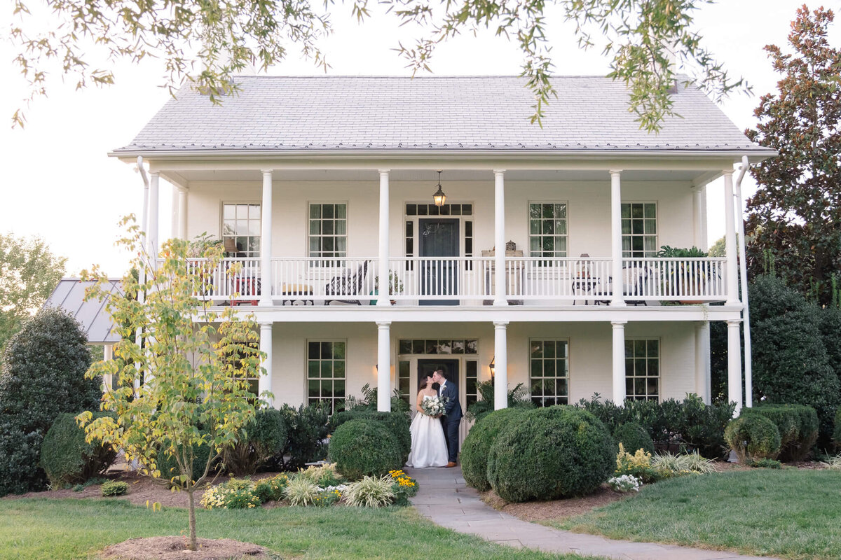 Bride and Groom taking portraits in front of the main house at Glen Ellen Farm.