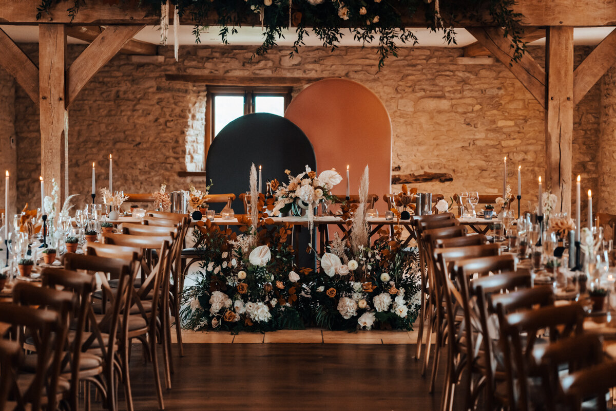 bohemian wedding reception setup with long tables, during a party at a Cotswolds wedding Venue
