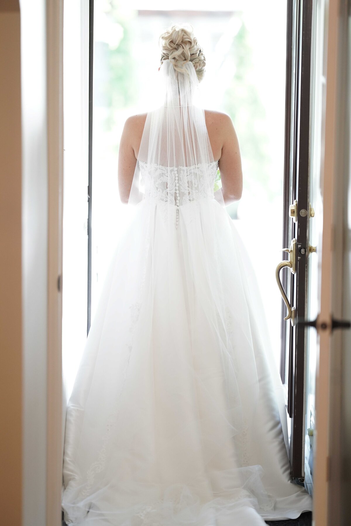 A view of the wedding dress from behind highlights the intricate details and elegant design of the gown. This image showcases the beauty and craftsmanship of the bridal attire, capturing the sophisticated and timeless aspects of our bridal portrait photography.