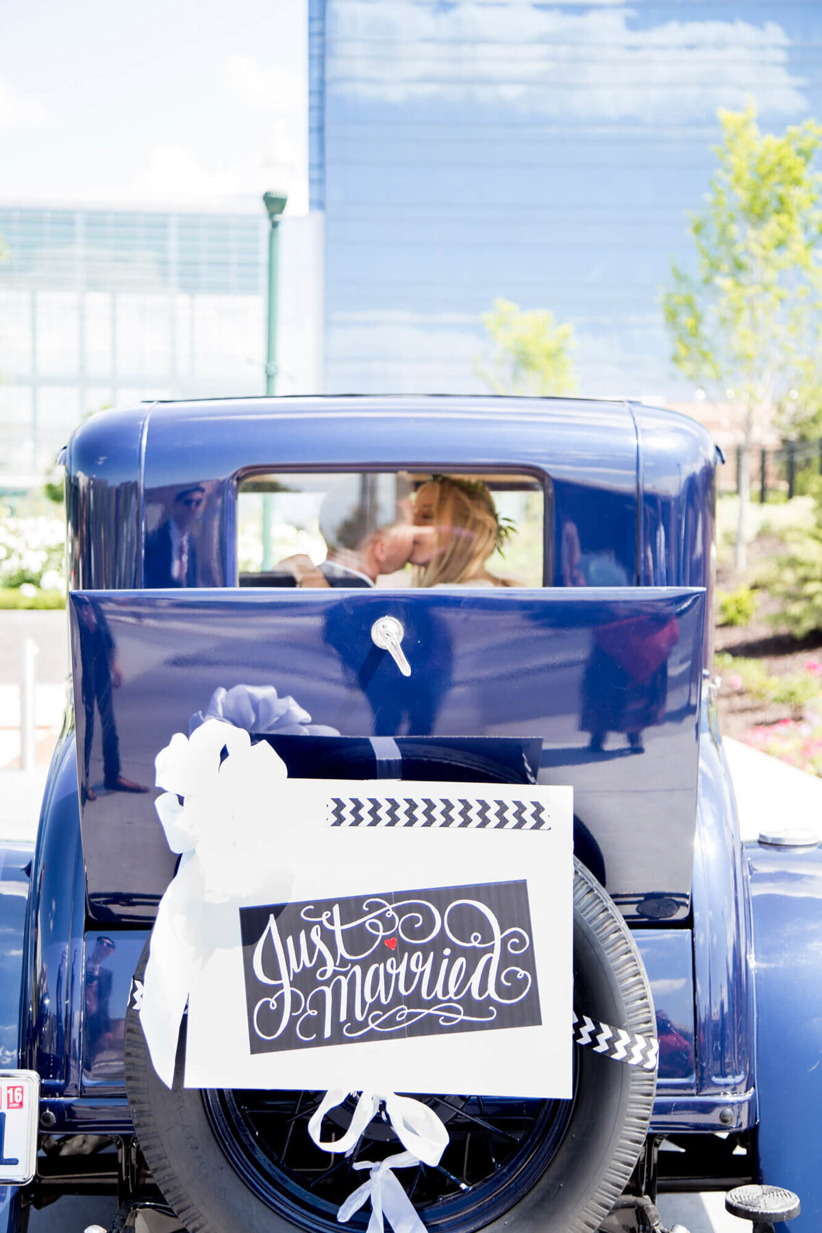 Just married sign on a blue vintage car after a sunny lds temple wedding