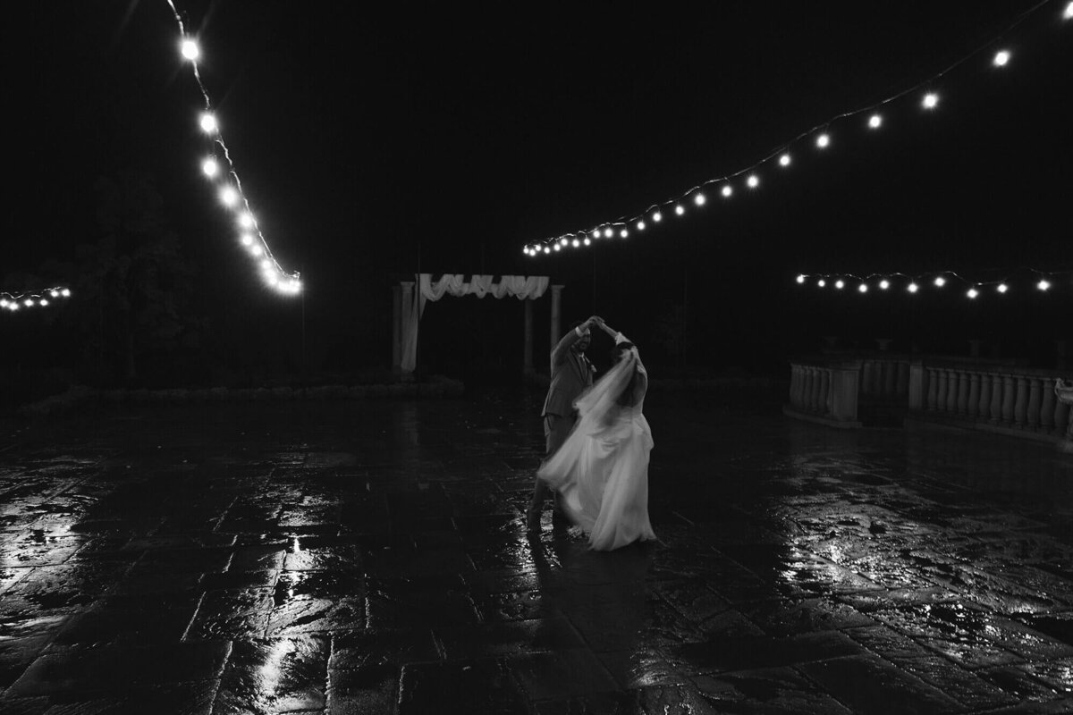 A groom twirls the bride in a dance outdoors at a wedding planned by Birdie June Events.