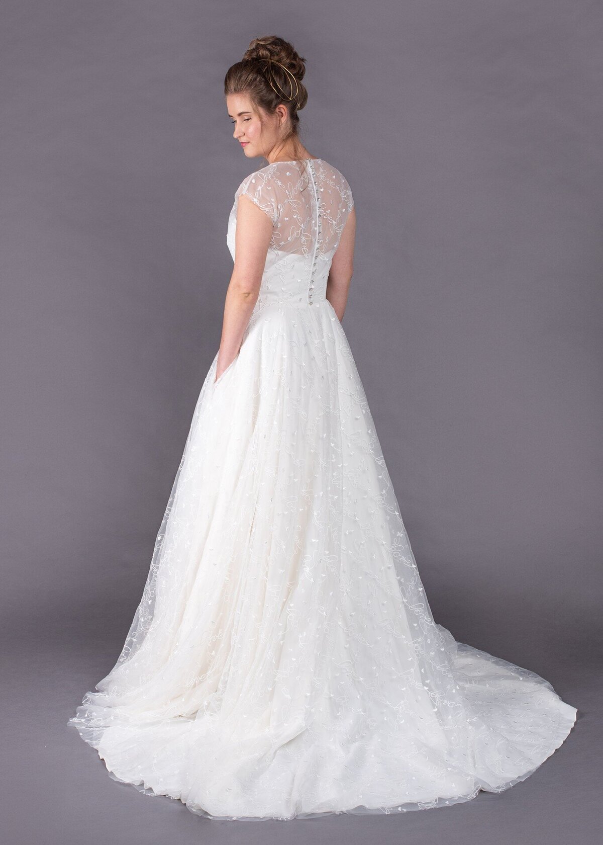 The Norma Jean wedding dress style is a combination of a high illusion neckline and a full a-line skirt with pockets.