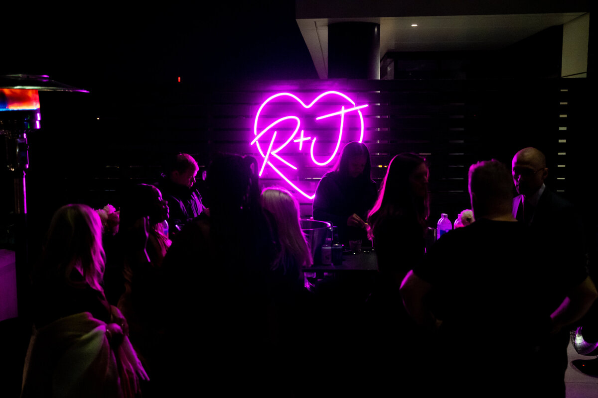 R&J pink neon sign lights up the night rooftop at a wedding at The Terrace in Columbus, Ohio.