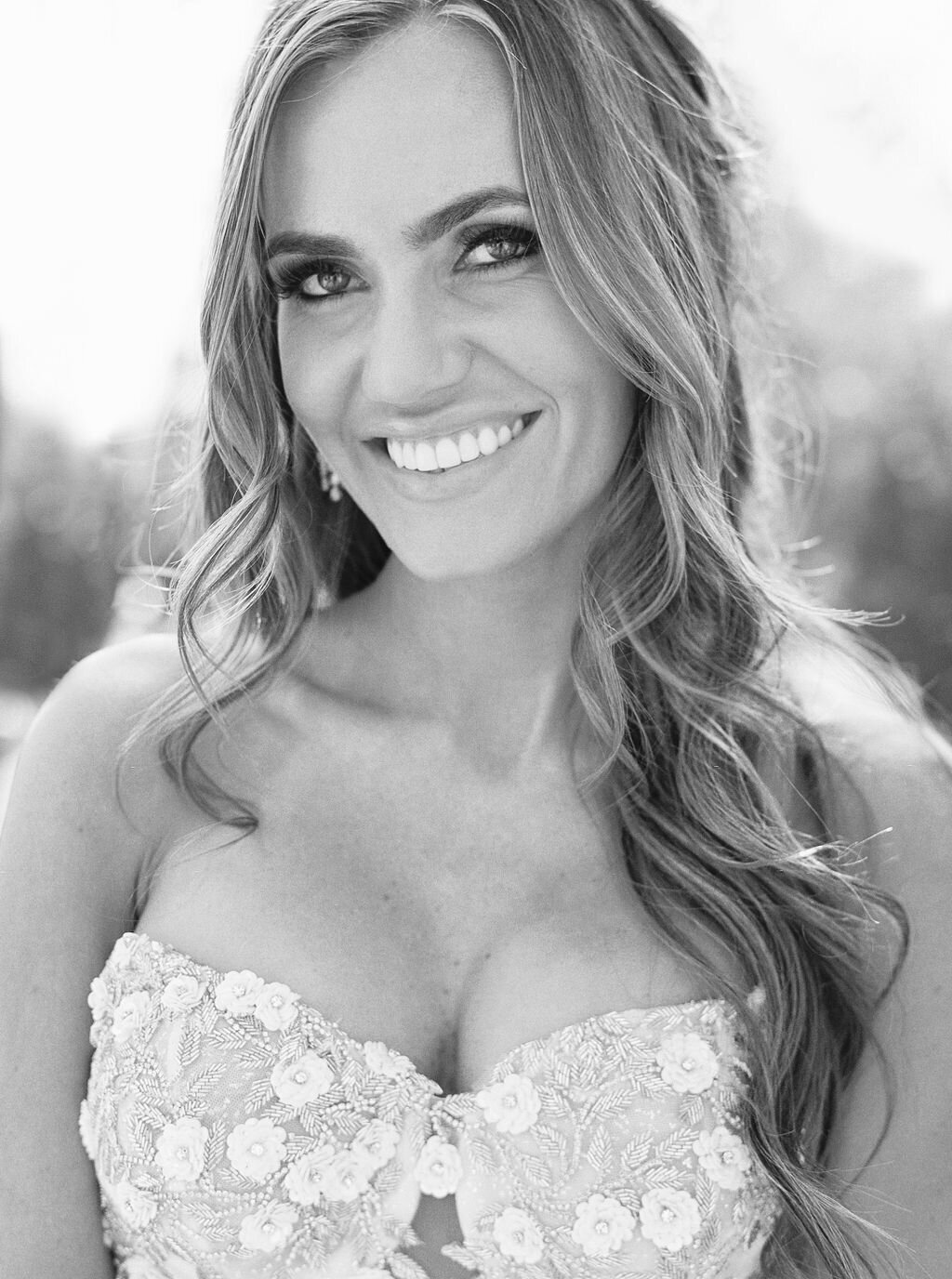 A stunning bridal portrait featuring an elegant bride in a lace wedding gown with delicate floral embellishments. Capturing timeless beauty and wedding day joy.