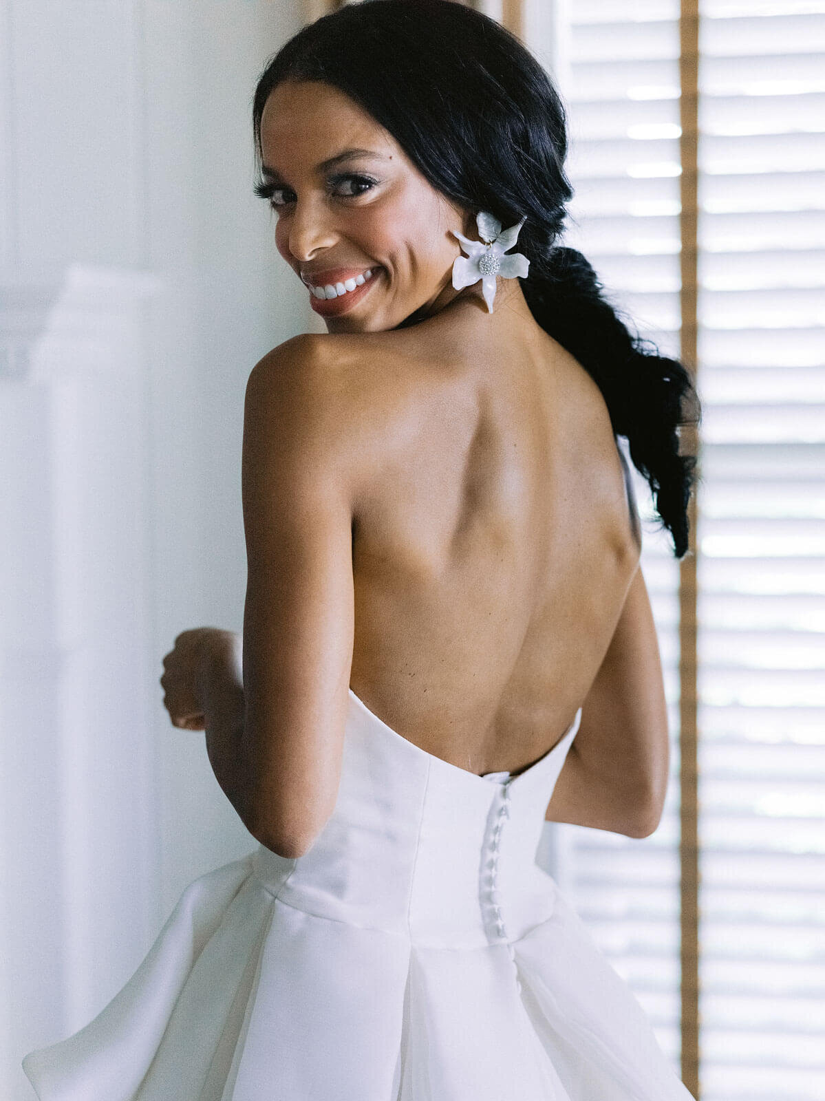 The beautiful bride is showing off her backless gown in Montage at Palmetto Bluff. Destination wedding image by Jenny Fu Studio