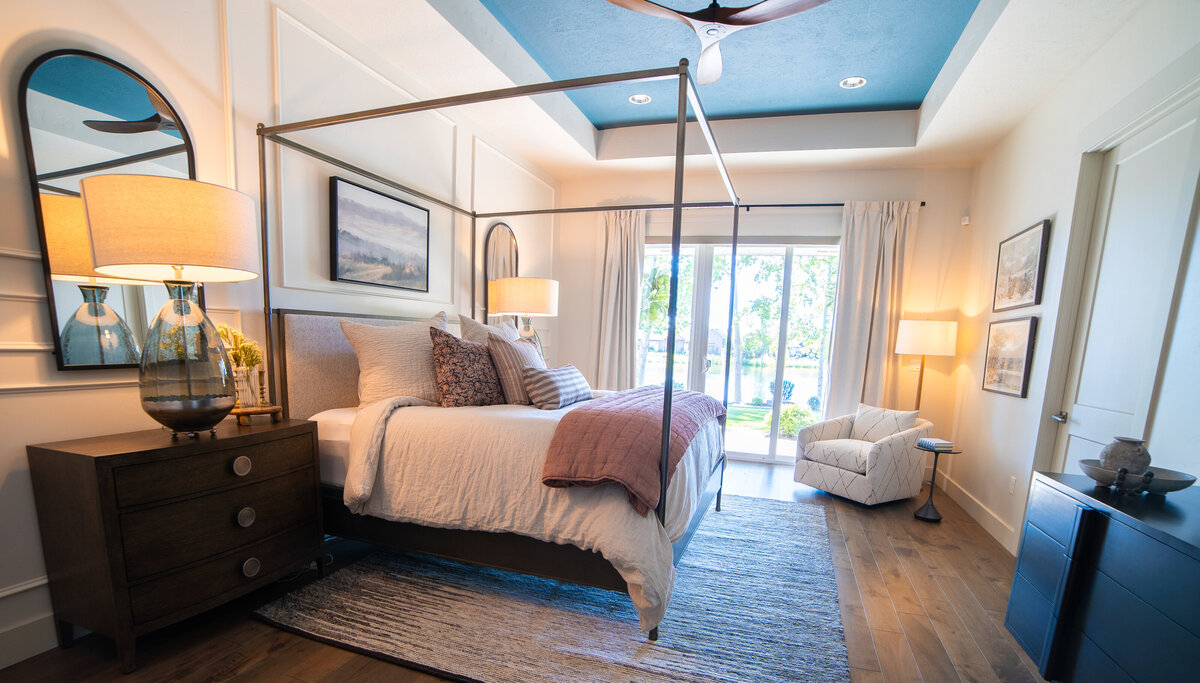 luxury bedroom with white dresser white sitting chiar and bed with blue blanket