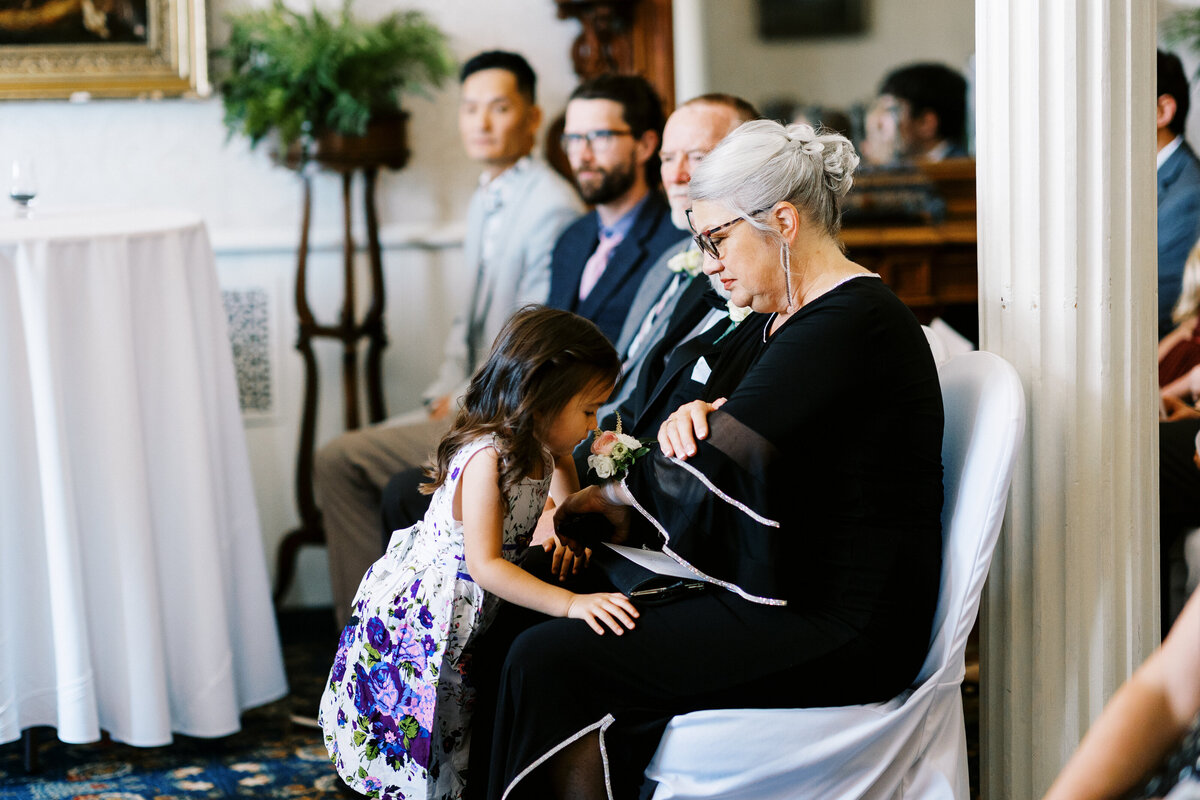 flower girl  is smelling  flower corsage at the ceremony