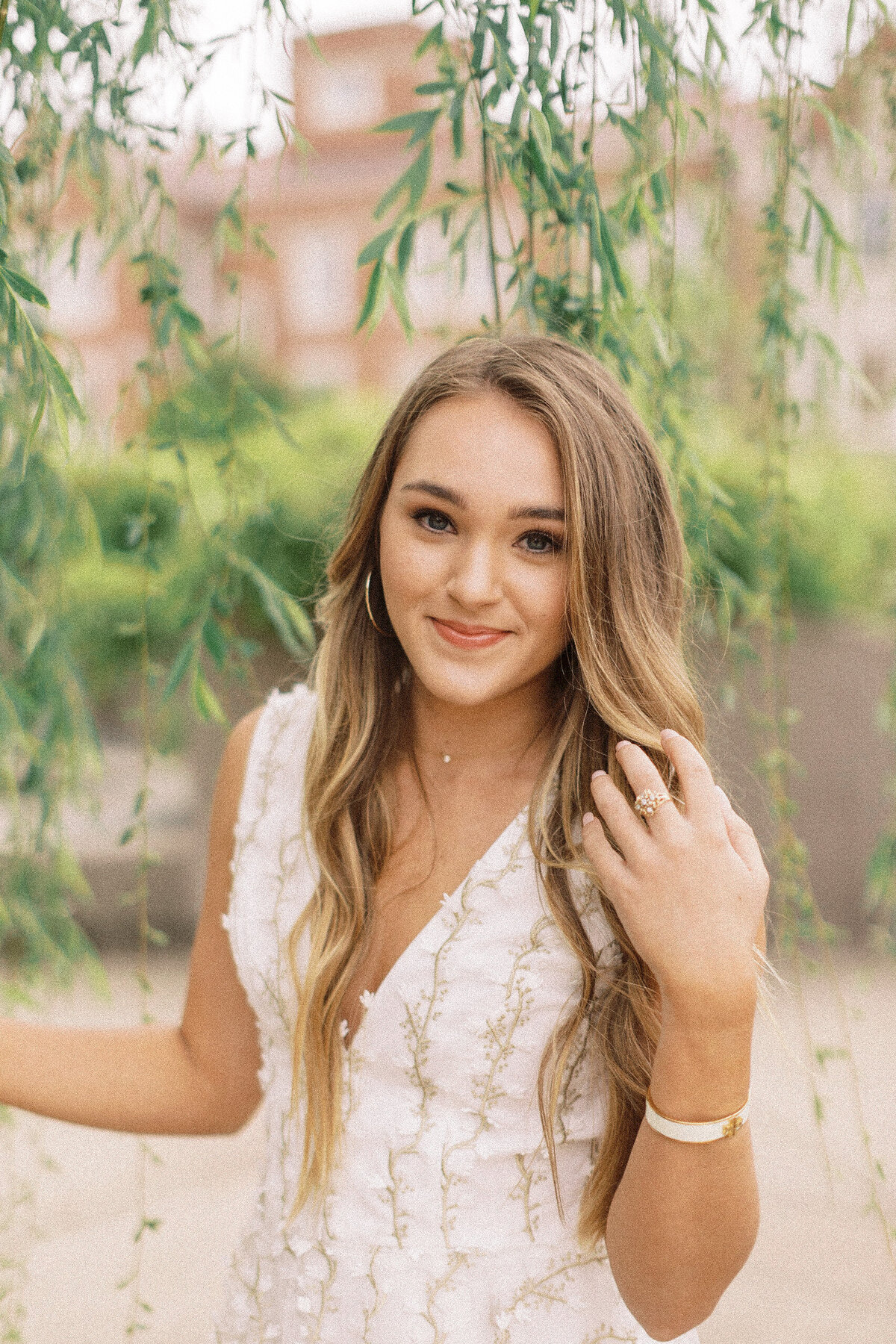 college aged woman poses under willow tree at university of oklahoma