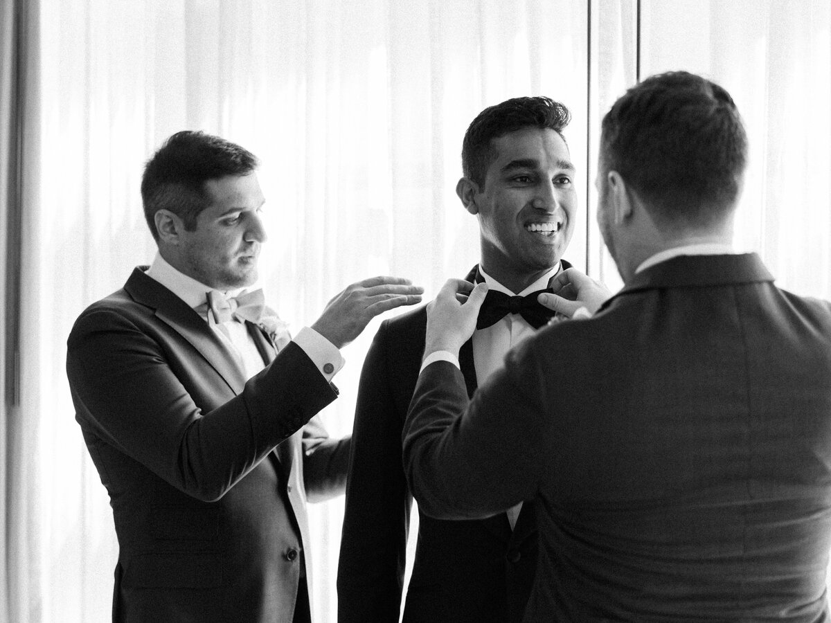 A groom gets ready for his wedding with his groomsmen