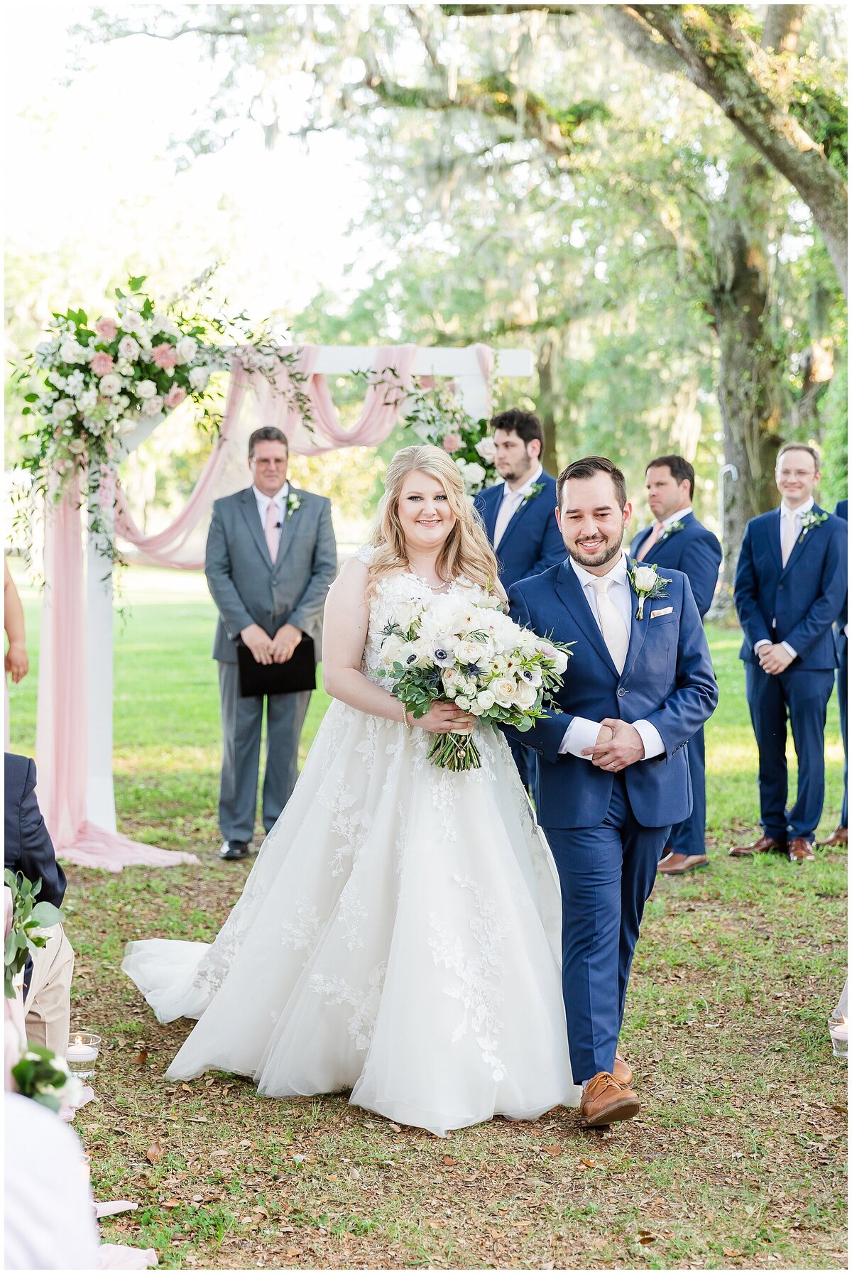 bride and groom walking down the aisle at the old place