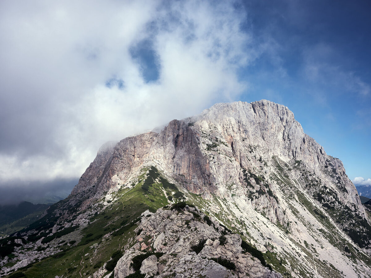 Majestätischer Blick auf den Trogkofel am Naßfeld – alpine Kulisse mit dramatischer Wolkenstimmung, fotografiert von Atelier Schulte – hochwertige Landschaftsfotografie in Kärnten und den Ostalpen.