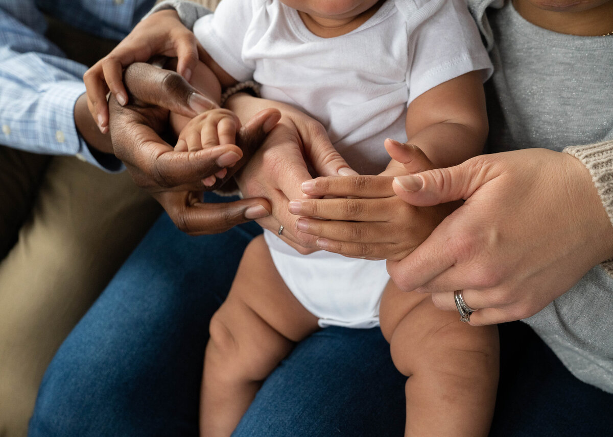 A family holding their hands together to show how diverse they are.