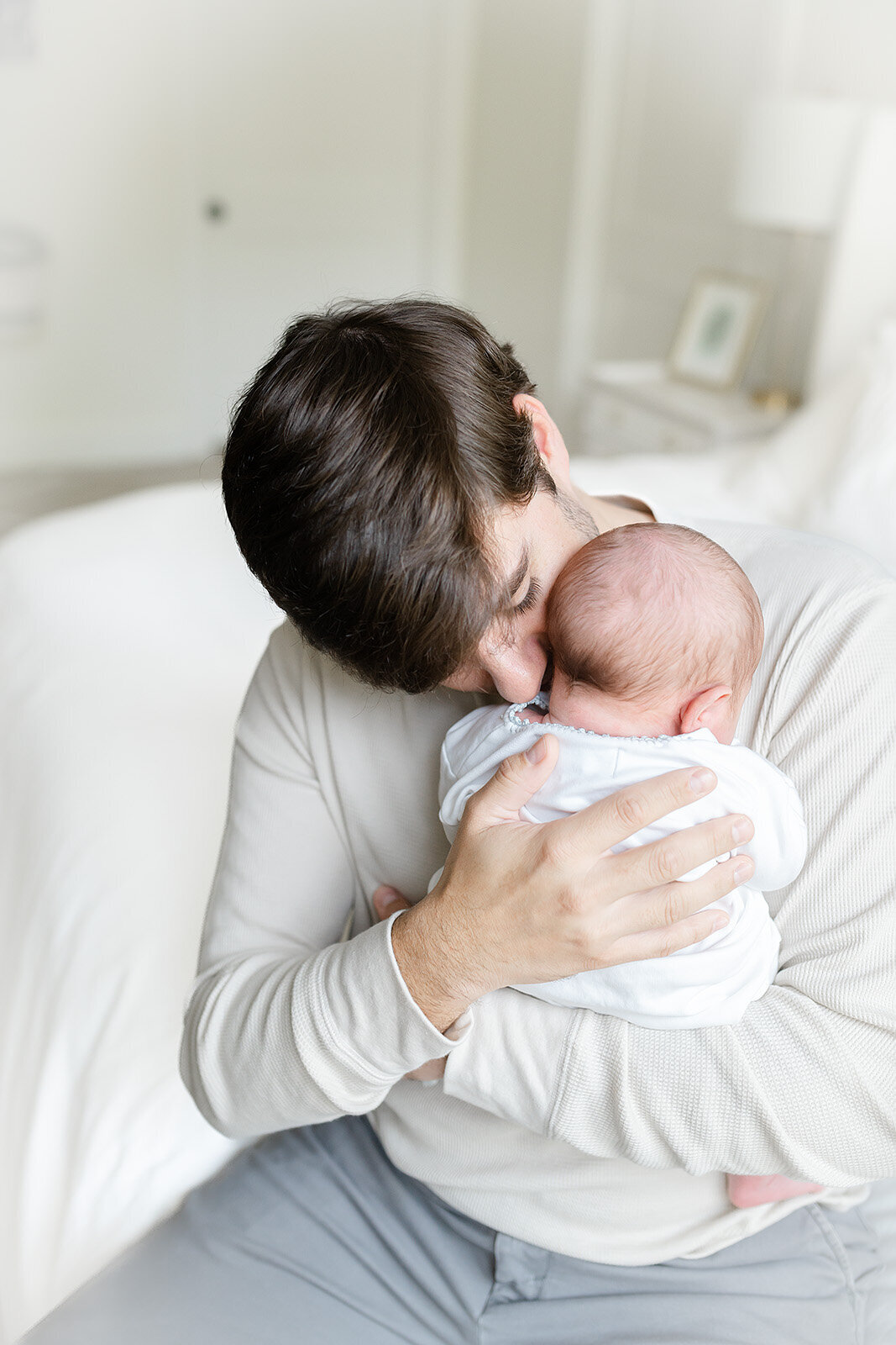 a father smelling his new babies neck