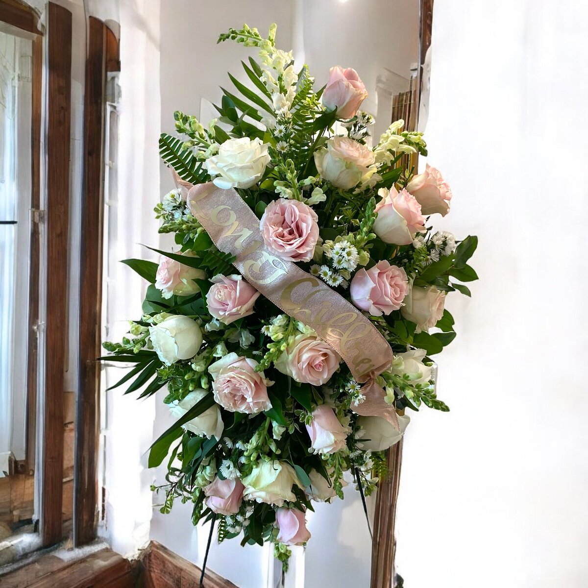 pink and white funeral side arrangement spray with loving Children on the ribbon