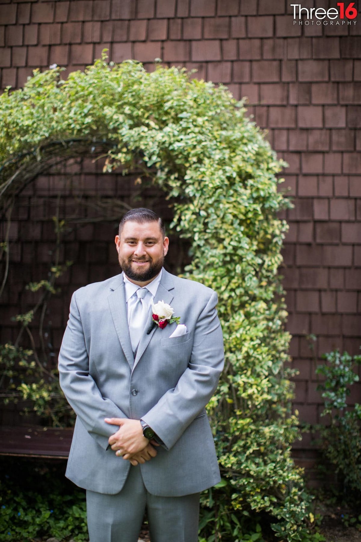 Groom poses for photos in his gray suit
