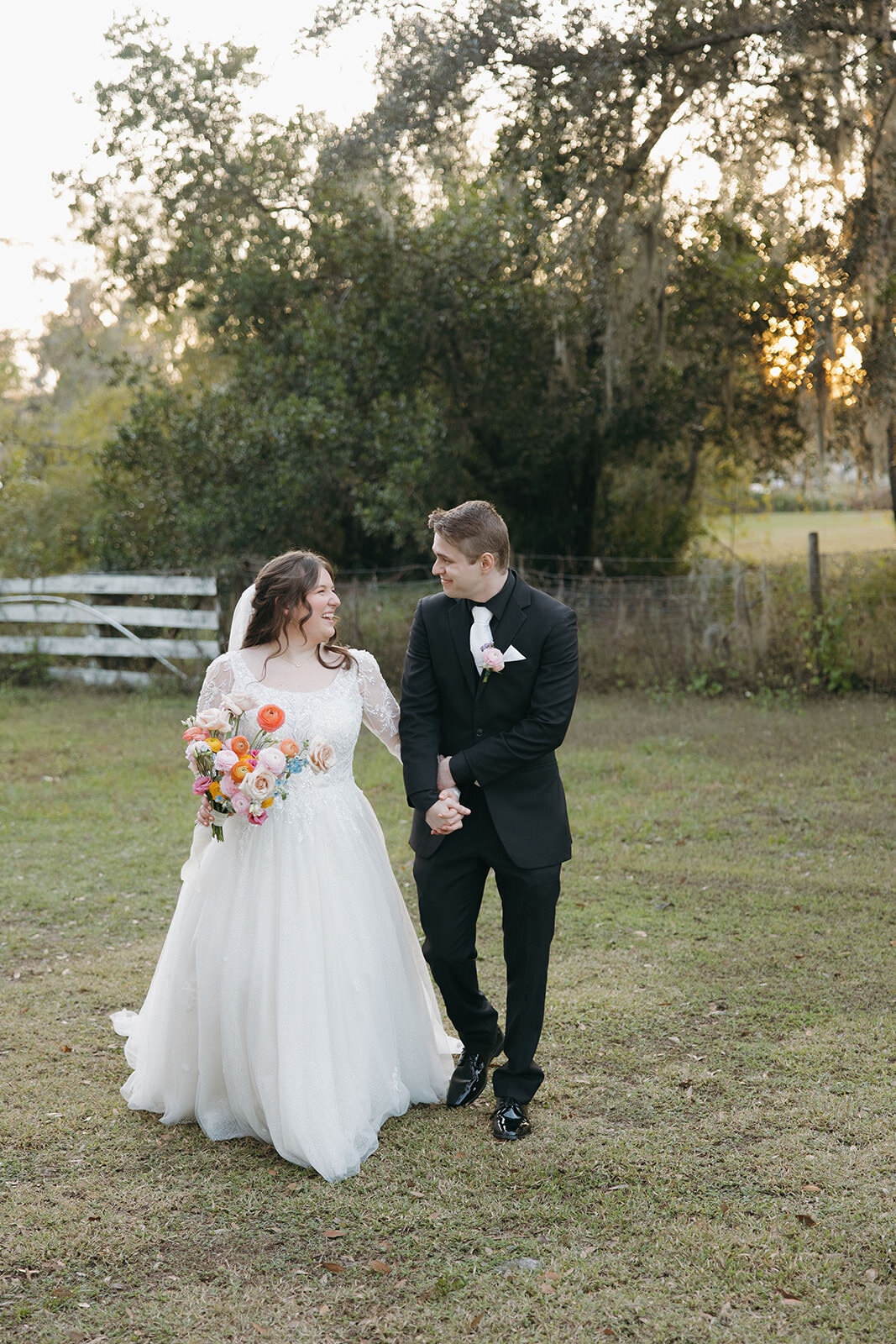 Bride and groom walking together on the lawn at Uliana Estate, a romantic wedding venue in Lakeland Florida.