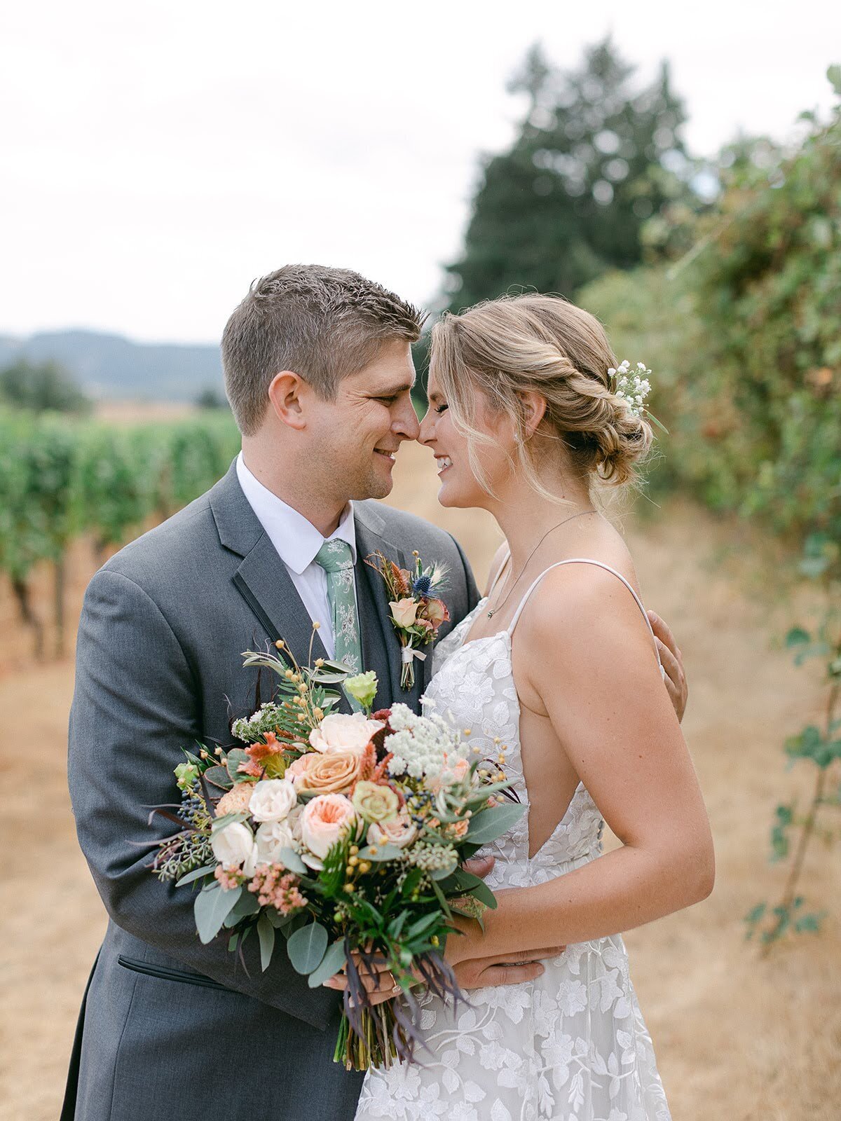 Bride leans in towards groom and holds her wedding bouquet.