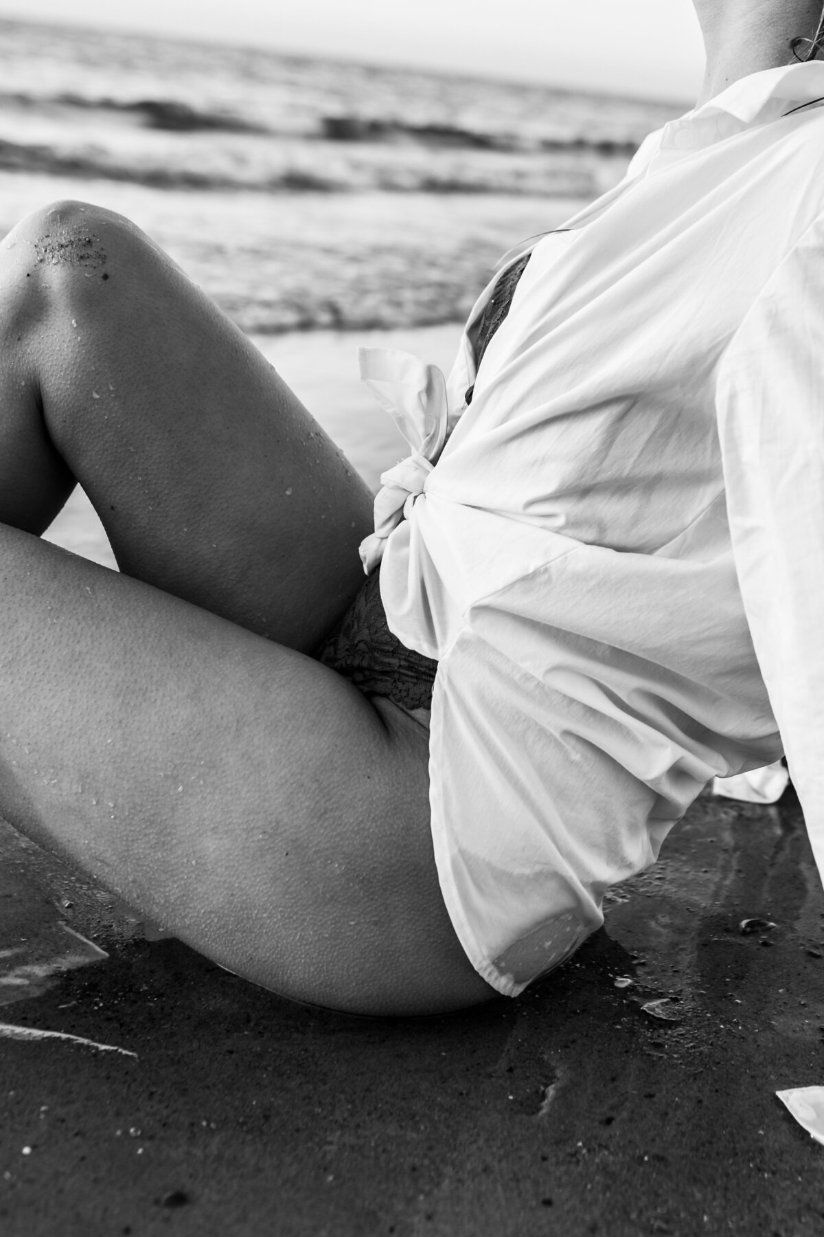 Artistic detail shot of hands resting gently on warm sand.