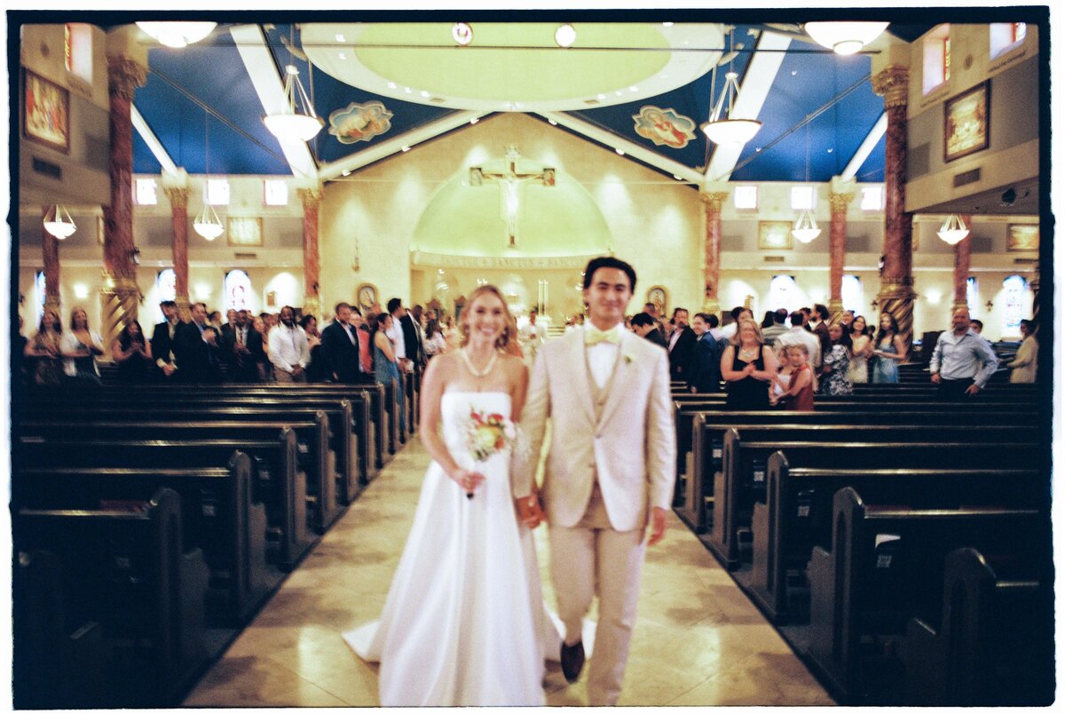 happy-married-newlyweds-walking-away-from-wedding-ceremony