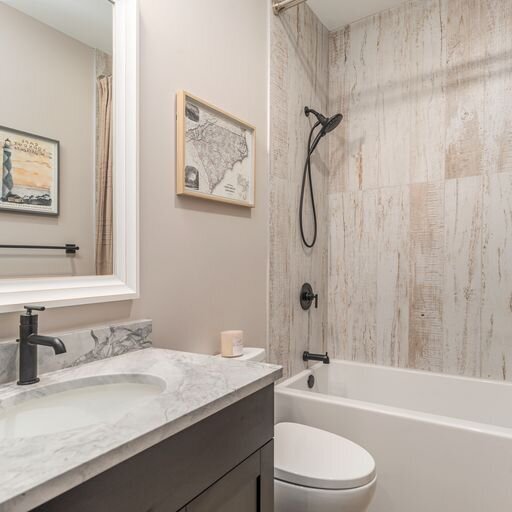 A bathroom with a tub, sink and mirror