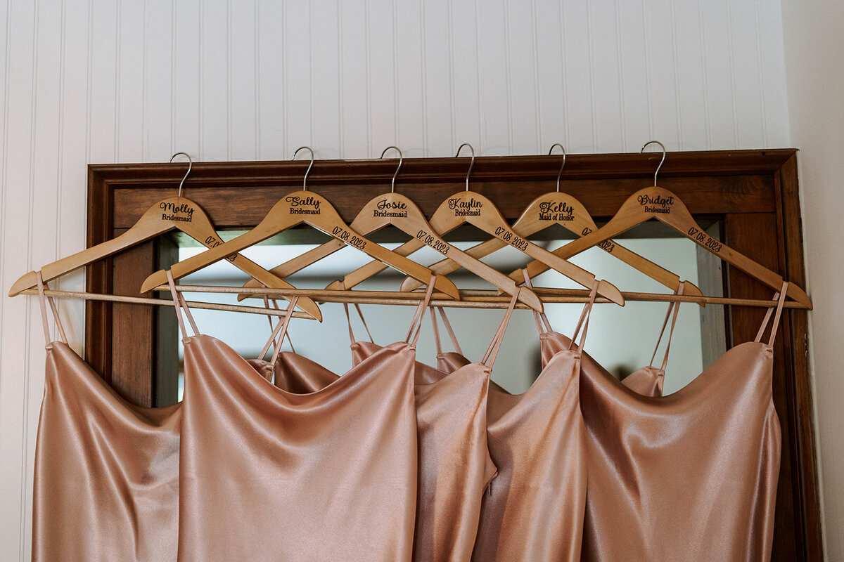 blush bridesmaids dresses on wood hangars in farmer cottage