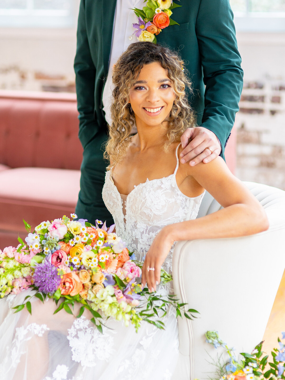 Bride smiling with groom's hand on her shoulder
