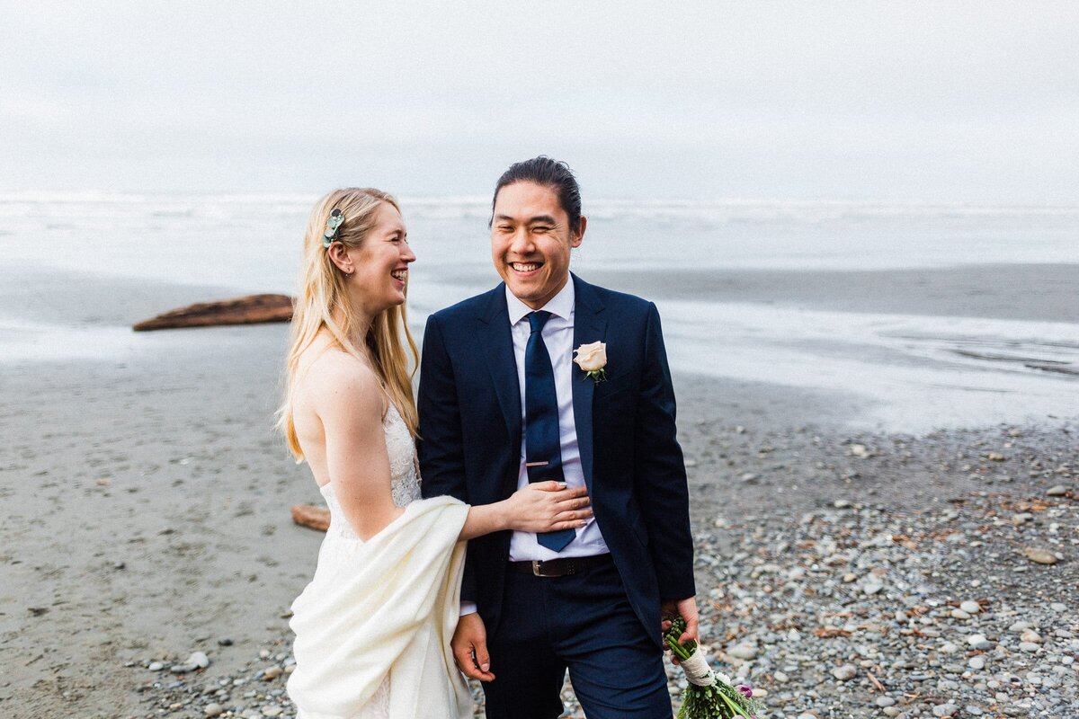 A Washington Elopement featuring an interracial couple giggling on the beach.