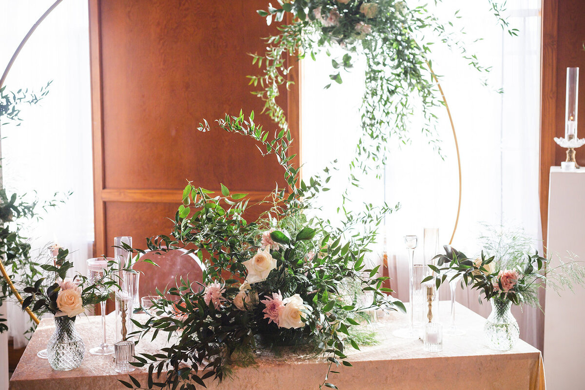 an arrangement of white and pink flowers sitting on a table