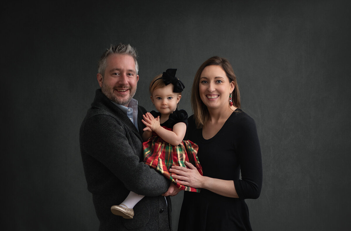 family portrait of parents with young daughter smiling at their st. louis family photography session