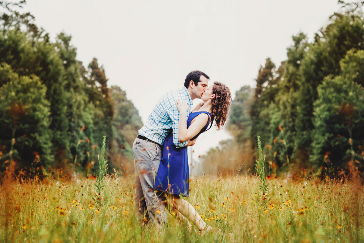 Couple sharing a romantic kiss in a wildflower field during an engagement session in Orlando Florida.