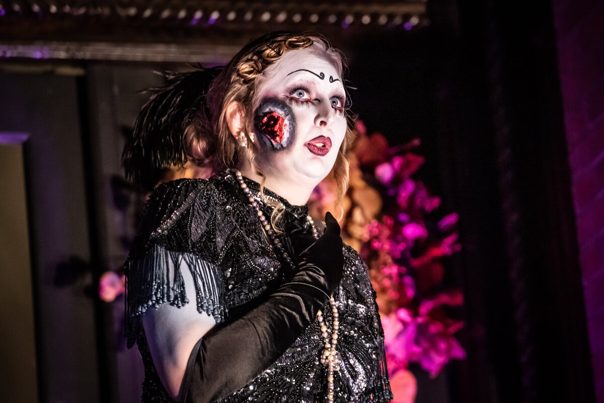 A person in theater makeup on stage
