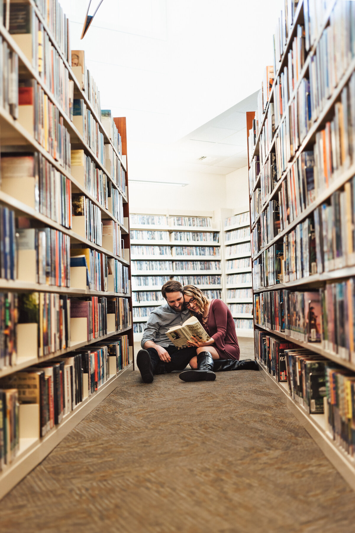 Bowling Green Kentucky family photographer. A couple sitting in the library snuggled reading a book.