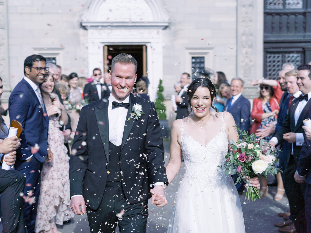 Bride and groom after ceremony with real flower petal confetti