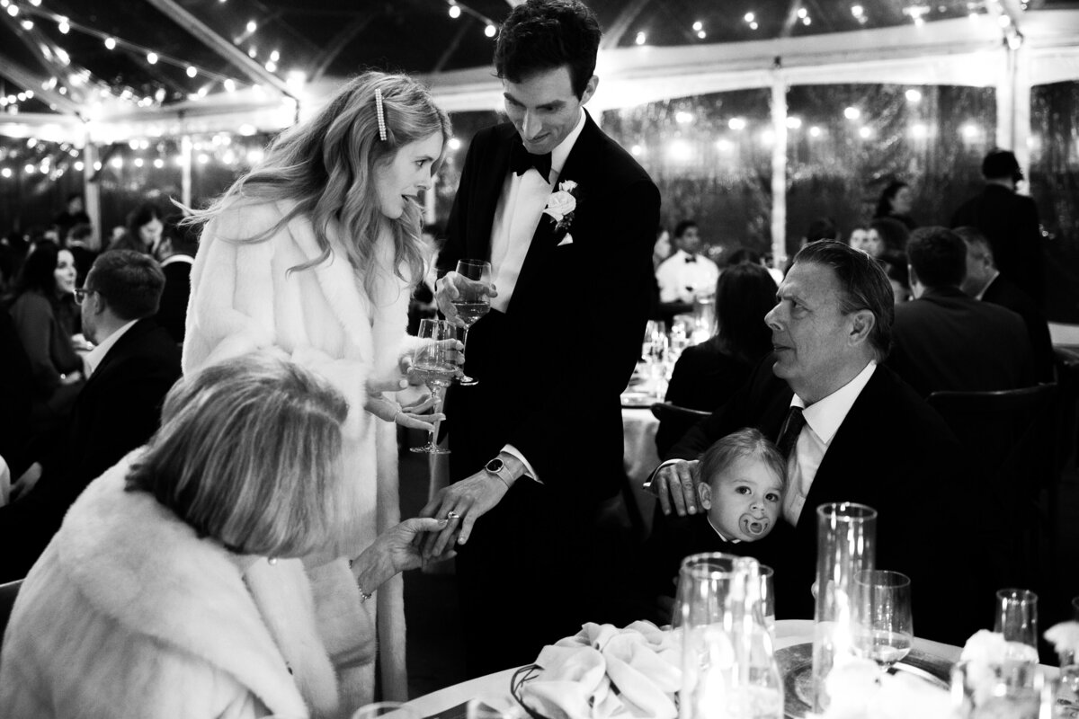 Timeless black and white wedding image of newlyweds showing rings to their grandparents, by Kate Winters Photography.