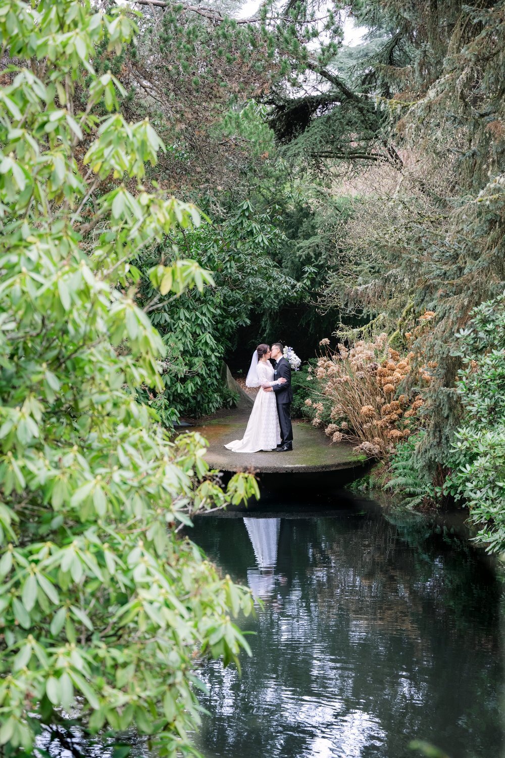 wedding couple kiss by pond in kubota garden