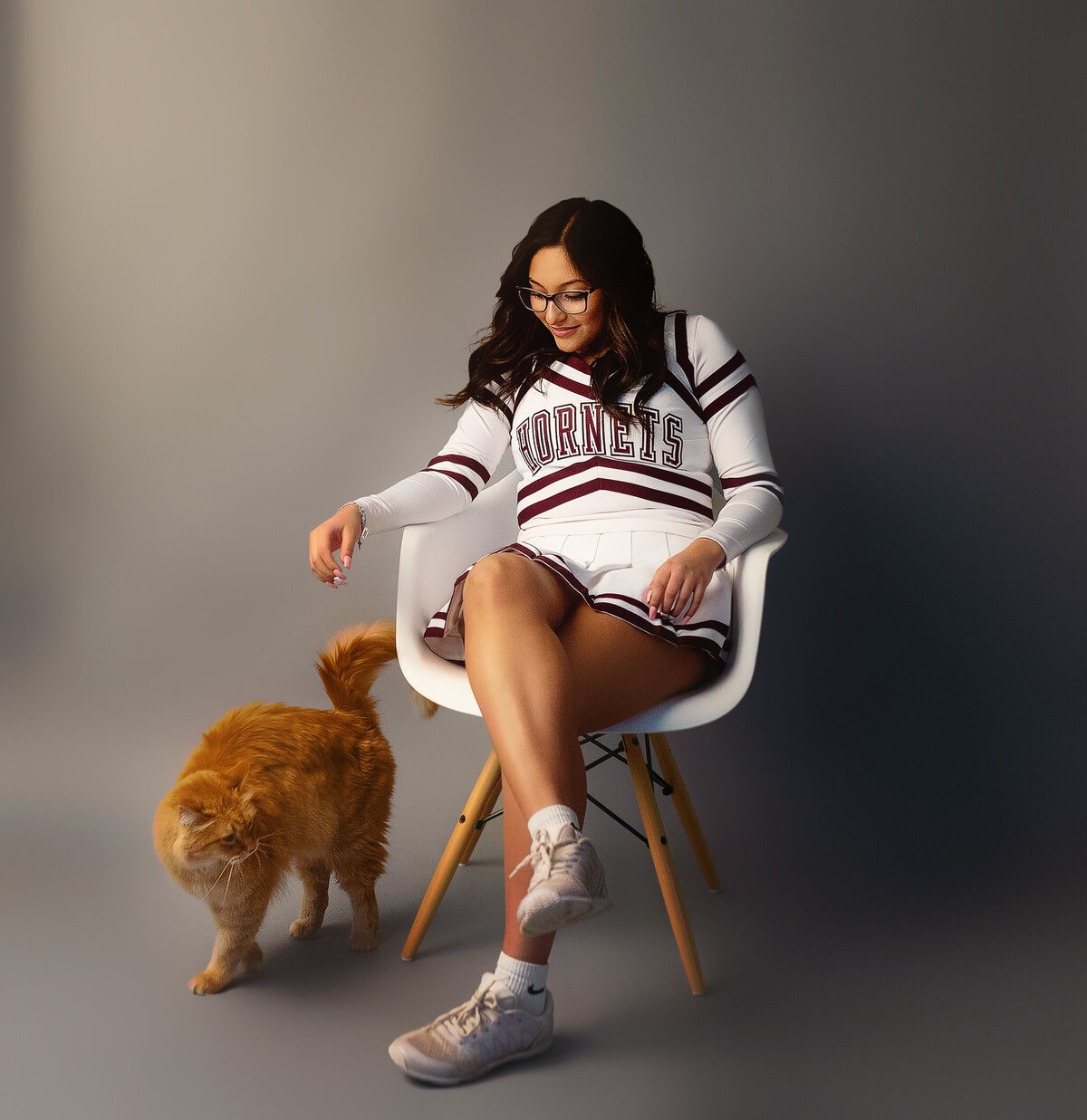high school cheerleader in studio session with a cat