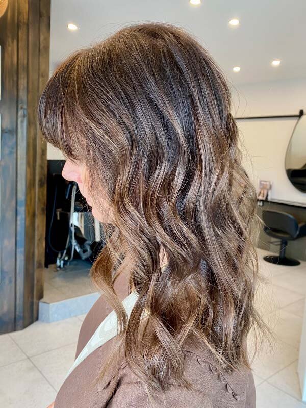Honey blonde balayage styled in loose waves, representing salon-quality hair dye and cut & blowdry packages in Sydney.