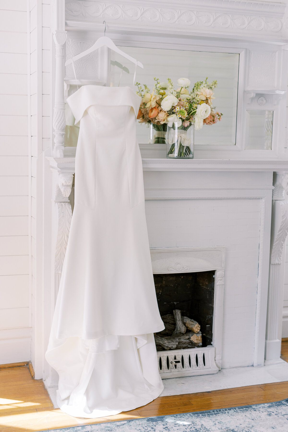 Wedding dress draped next to a fireplace