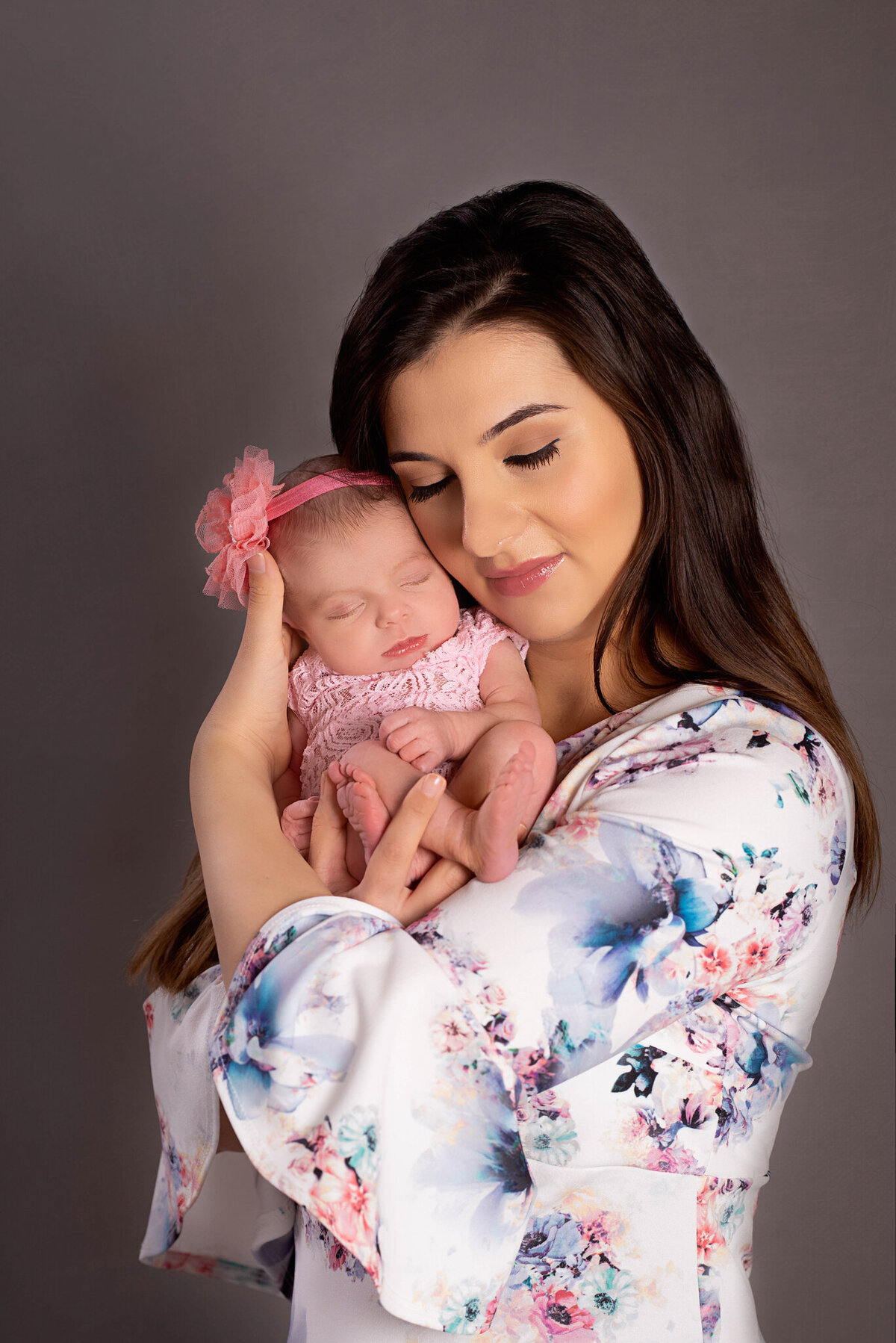 Heartwarming portrait of a mother holding her newborn baby close, captured in Overland Park, Kansas. A touching moment for families seeking intimate and loving newborn photography.