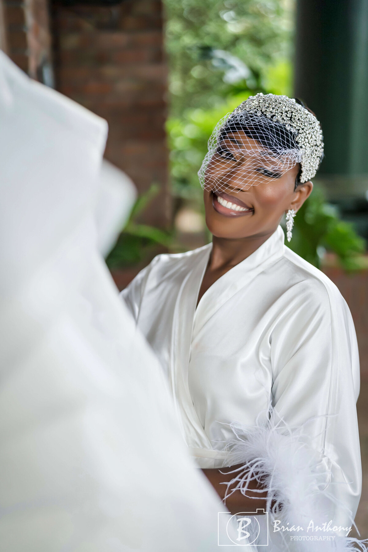 Radiant bride getting ready in a cozy white robe, sharing a joyful moment before the ceremony.