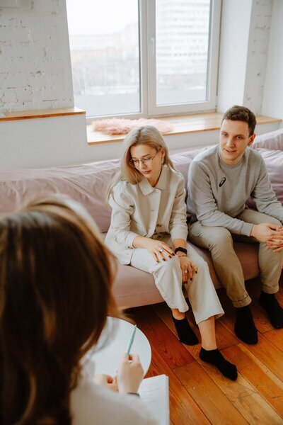 Couples sitting on a couch talking with a therapist