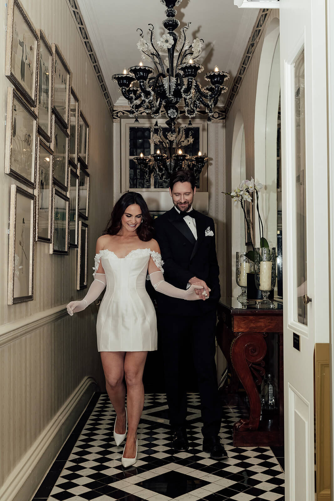 Glamorous Hollywood style couple come into a hotel after marrying.