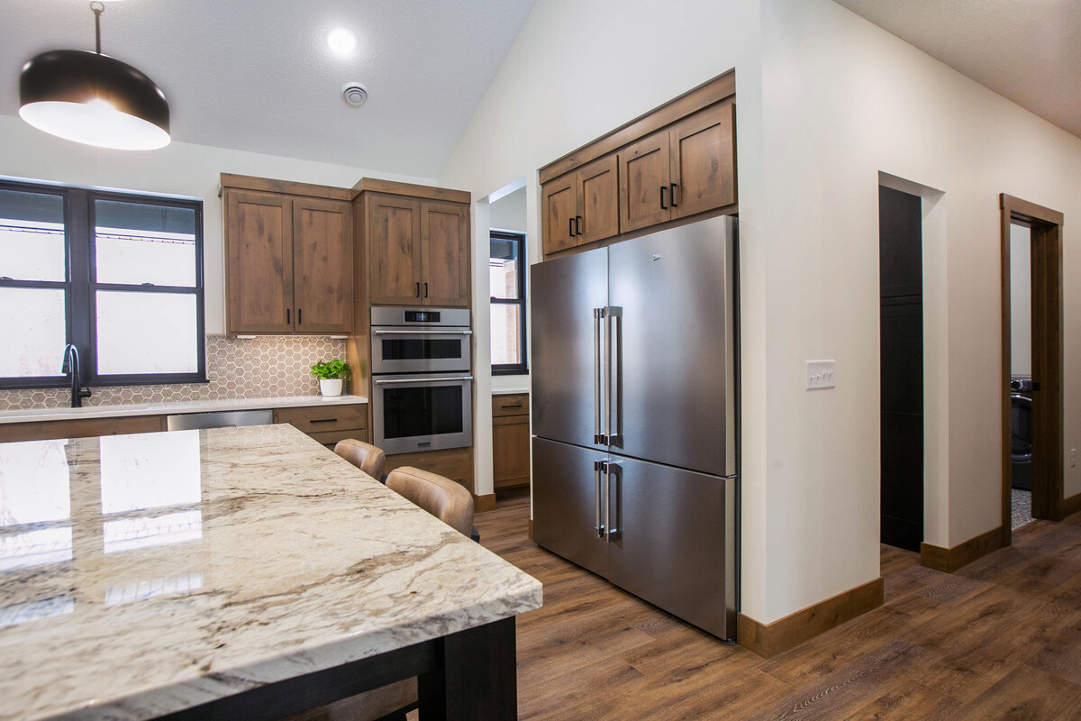 Open kitchen with dark cabinets, large island, and quartz countertops in an Elk River custom home