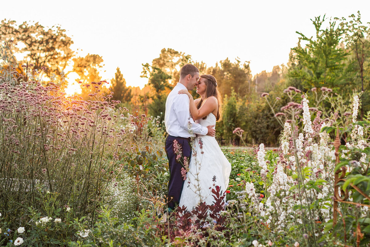 Wedding-couple-cuddle-in-field-of-flowers-during-golden-hour-at-Pine-Creek-Nursery-Monroe-WA-photo-by-Joanna-Monger-Photography