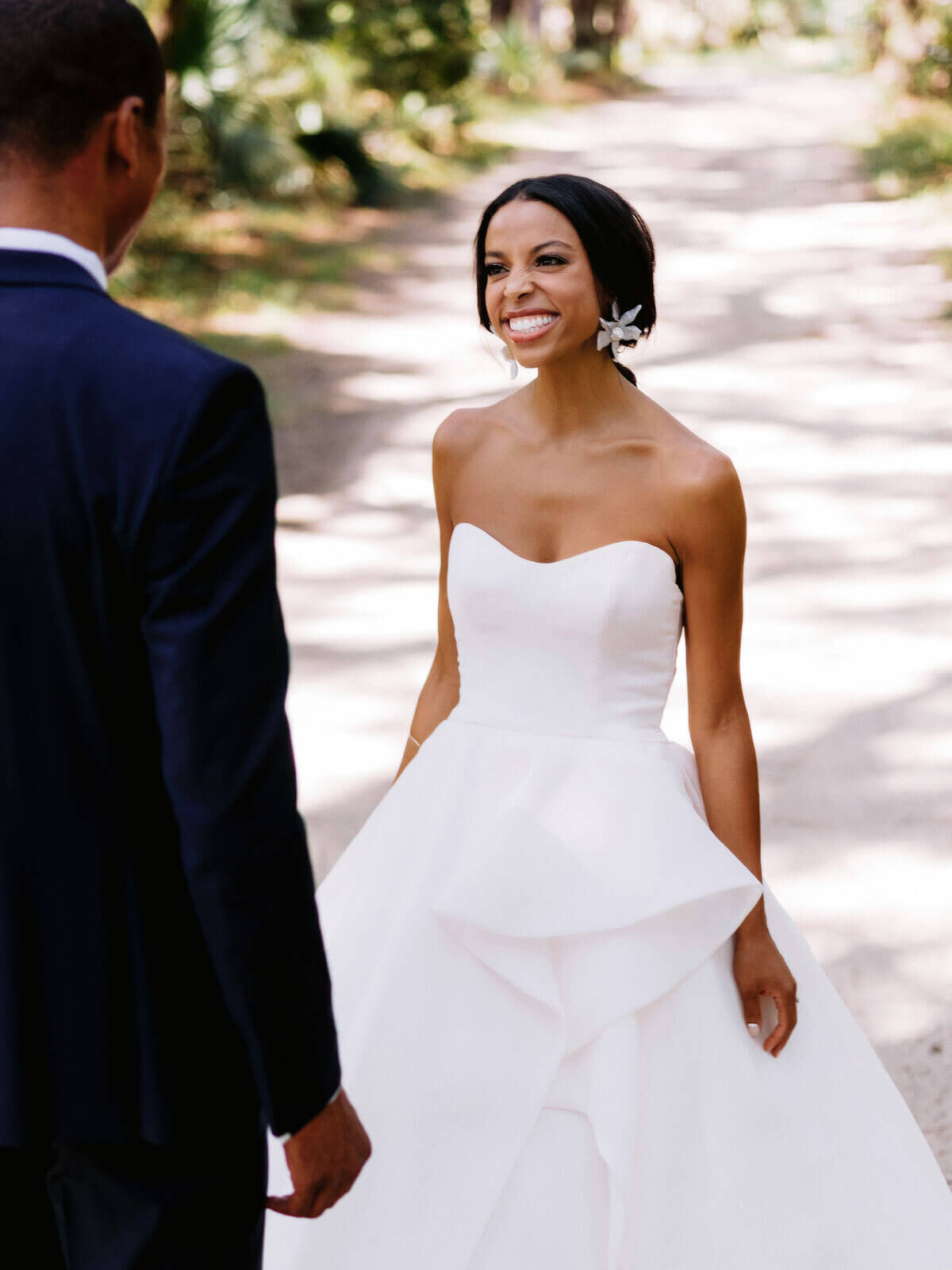 The bride is smiling broadly towards her groom in Montage at Palmetto Bluff. Destination wedding image by Jenny Fu Studio