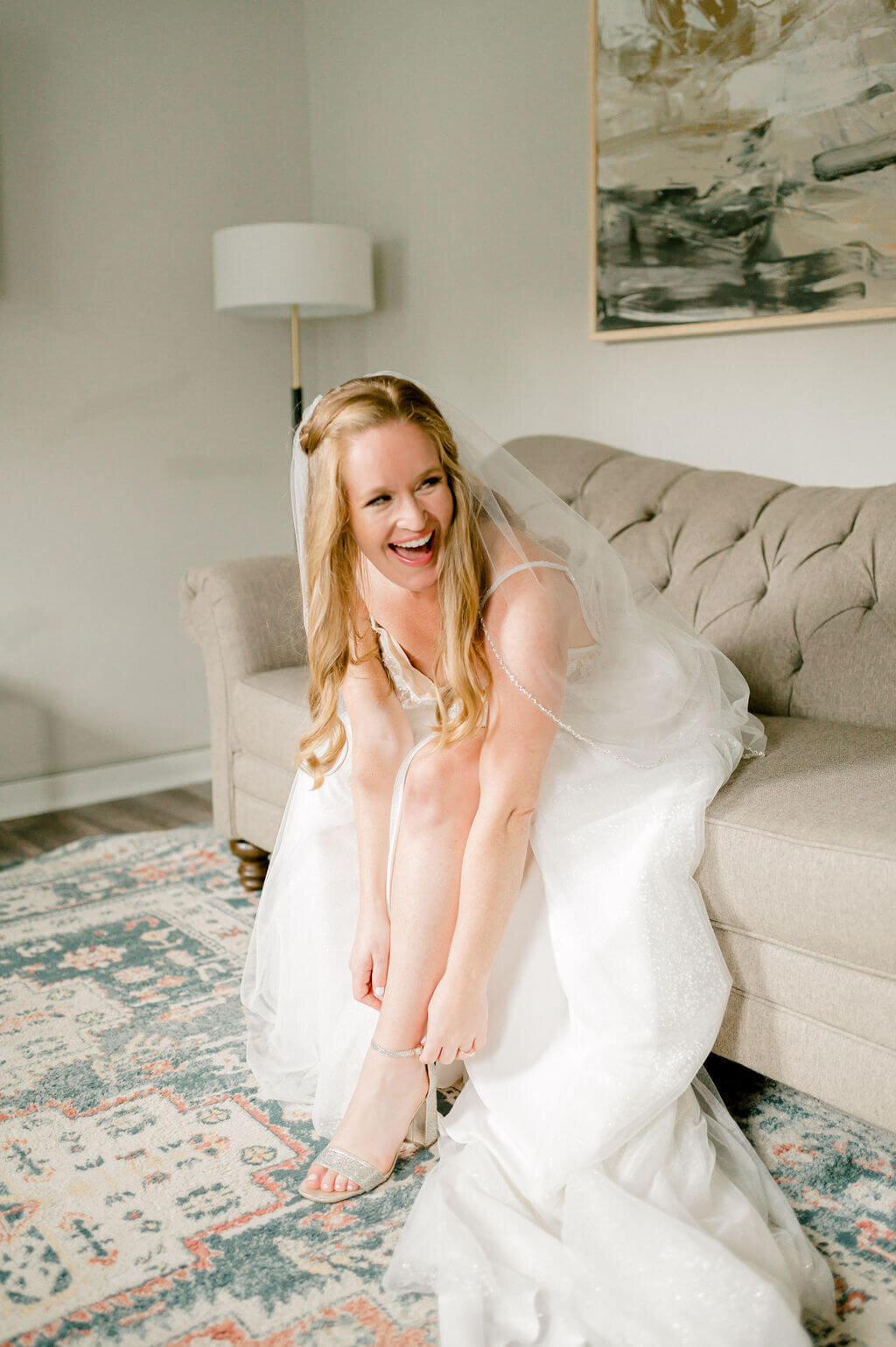 Bride looking excited as she puts on her shoes for her wedding day in DC.