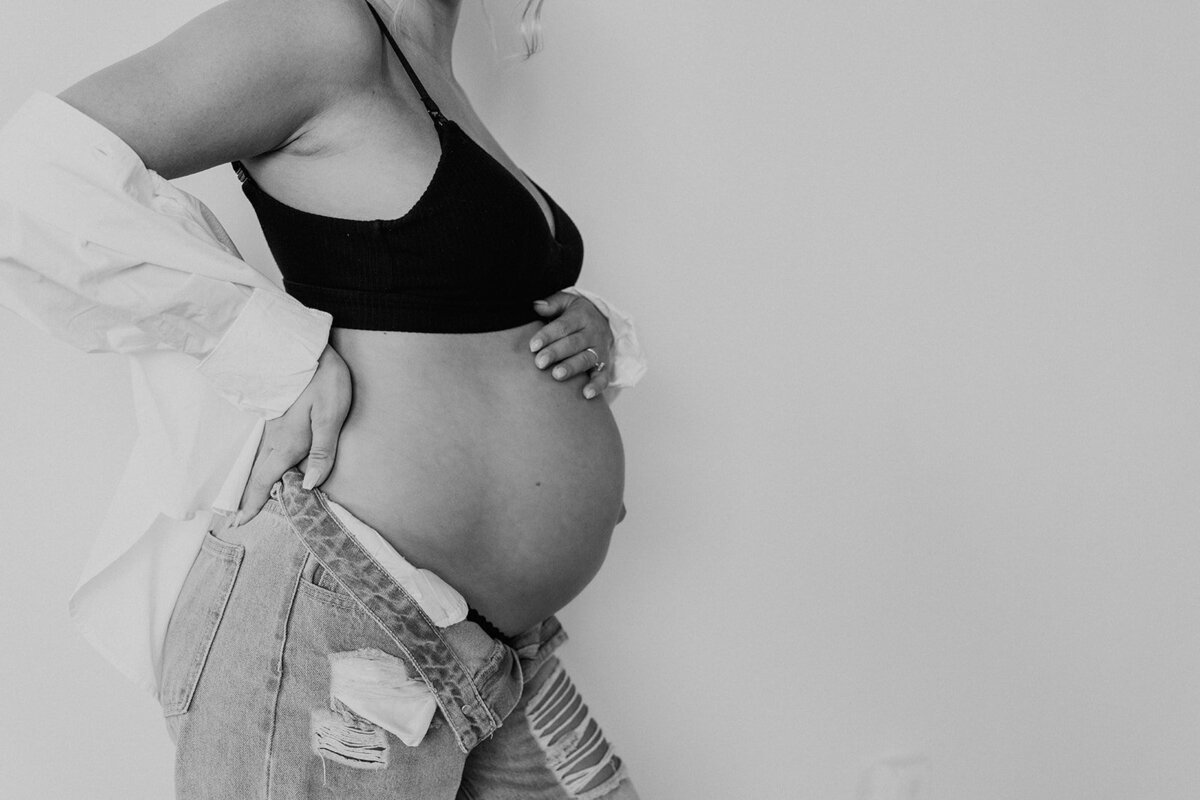 profile black and white image of a woman's pregnant belly